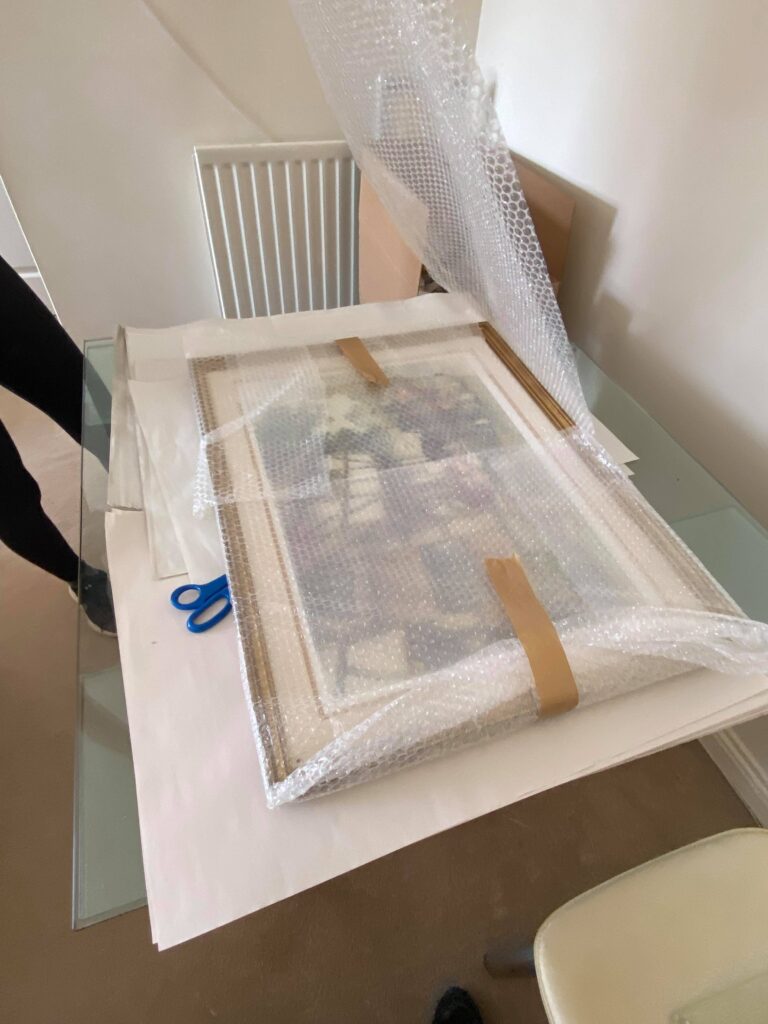 Framed artwork being wrapped in bubble wrap and protective paper for safe transport by Craig Atkinson Removals.
