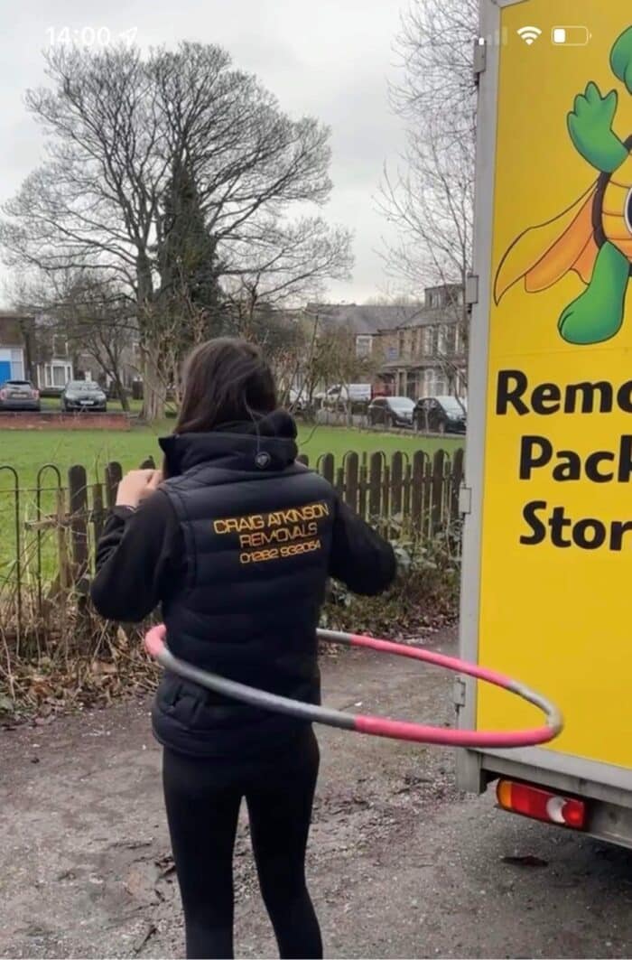 Craig Atkinson Removals team member hula hooping beside the removals van during a break.