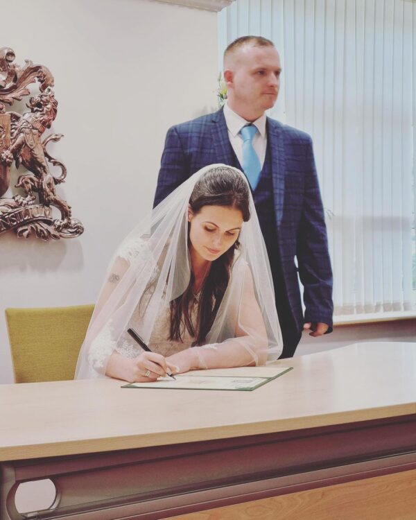 Craig and Jodie signing the register on their wedding day.