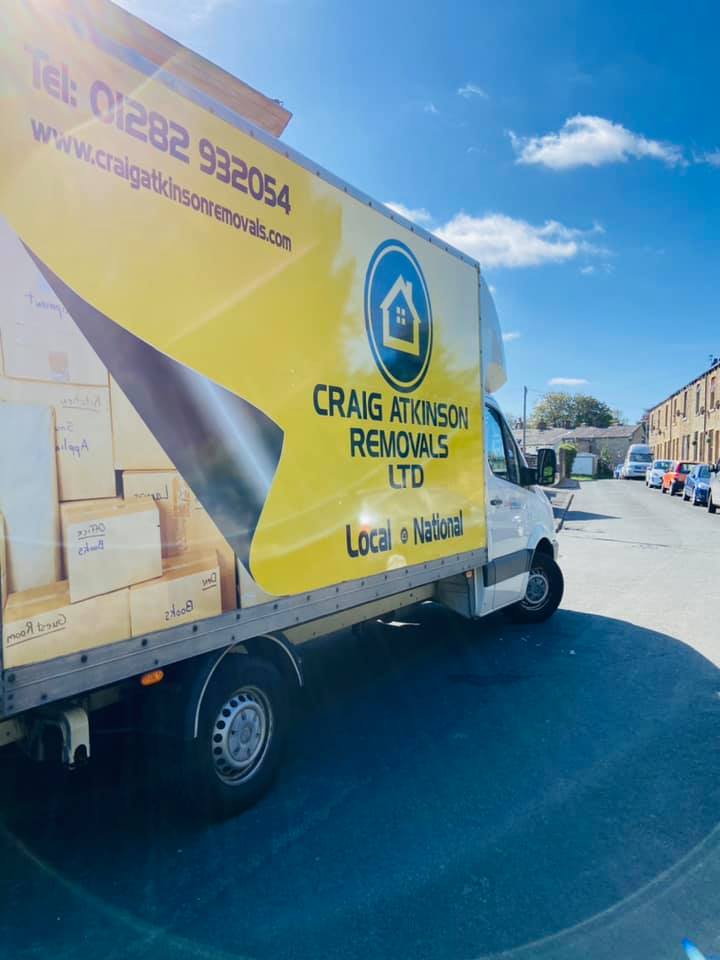 Craig Atkinson Removals van parked on a sunny street in Accrington, Lancashire, during a local home move.