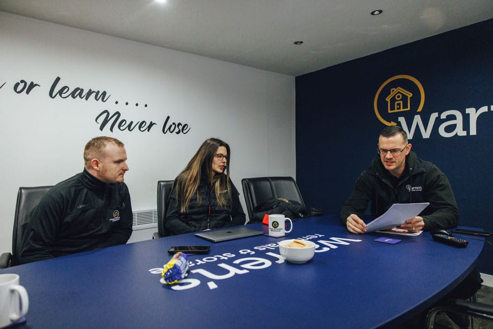 Craig Atkinson Removals and Warren’s Removals team members sitting around a meeting table discussing strategy.