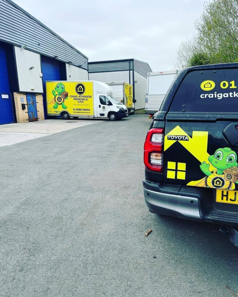 Craig Atkinson Removals vans and branded Toyota truck parked outside the company’s Burnley depot.