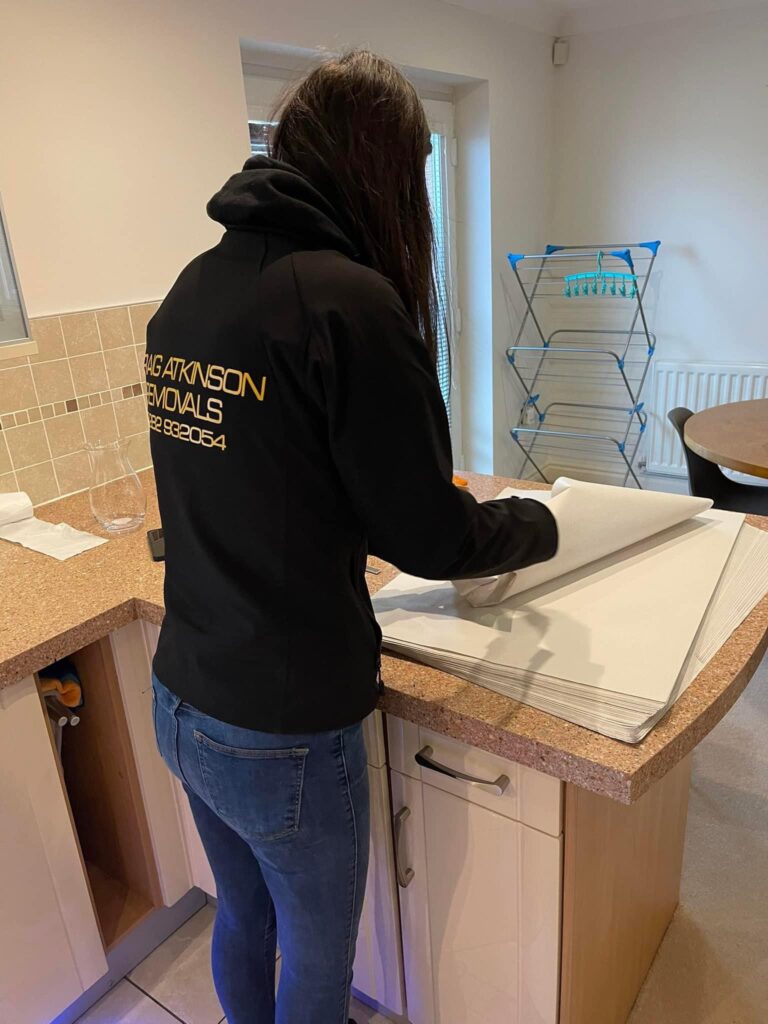 A Craig Atkinson Removals team member carefully wrapping household items as part of a professional packing service in Lancashire.