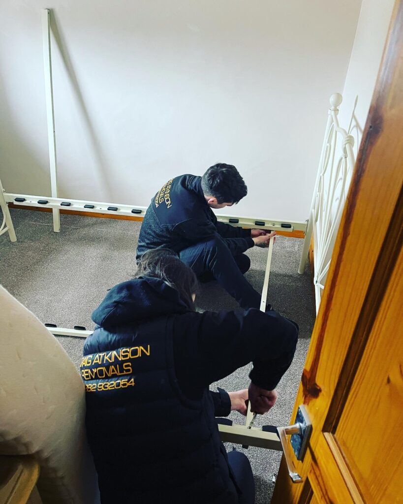 Craig Atkinson Removals team members assembling a bed frame in a Chorley home during a professional house move.