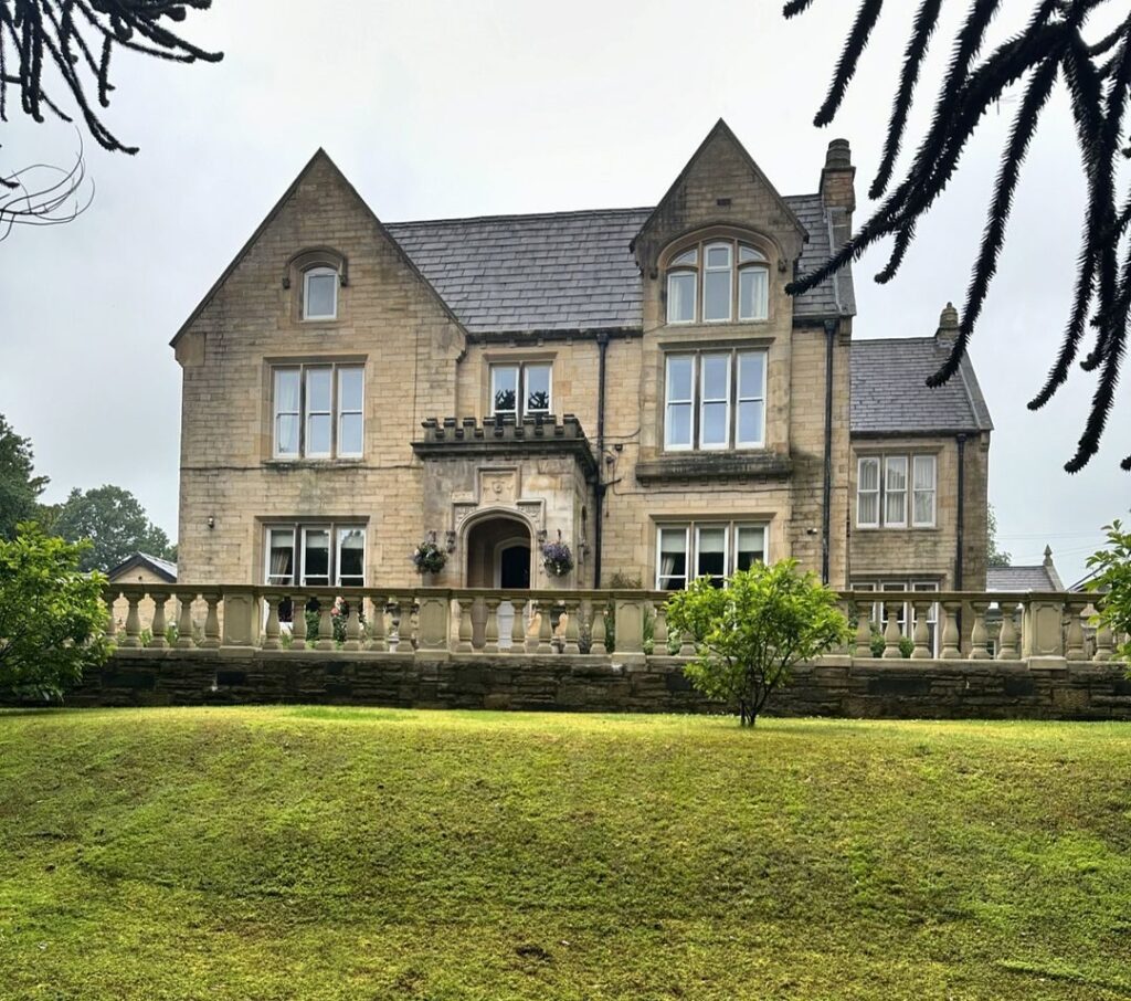 A grand stone mansion in Barrowford, Lancashire, surrounded by greenery, relocated by Craig Atkinson Removals.