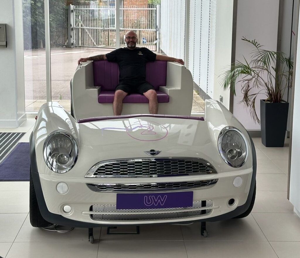 Craig Atkinson Removals team member sitting in a car-themed seat at Utility Warehouse’s London office.