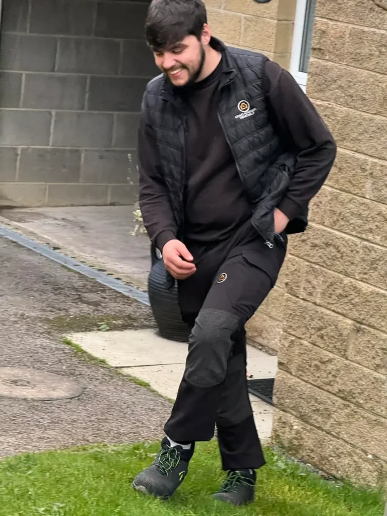 Connor from Craig Atkinson Removals smiling in uniform on his final day before leaving to pursue football coaching.