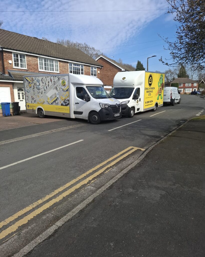 Craig Atkinson Removals vans parked outside homes during a house move, showcasing the company’s branded fleet in operation.