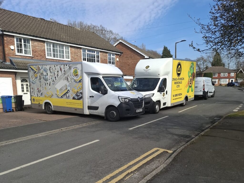 Craig Atkinson Removals vans parked outside homes during a house move, showcasing the company’s branded fleet in operation.