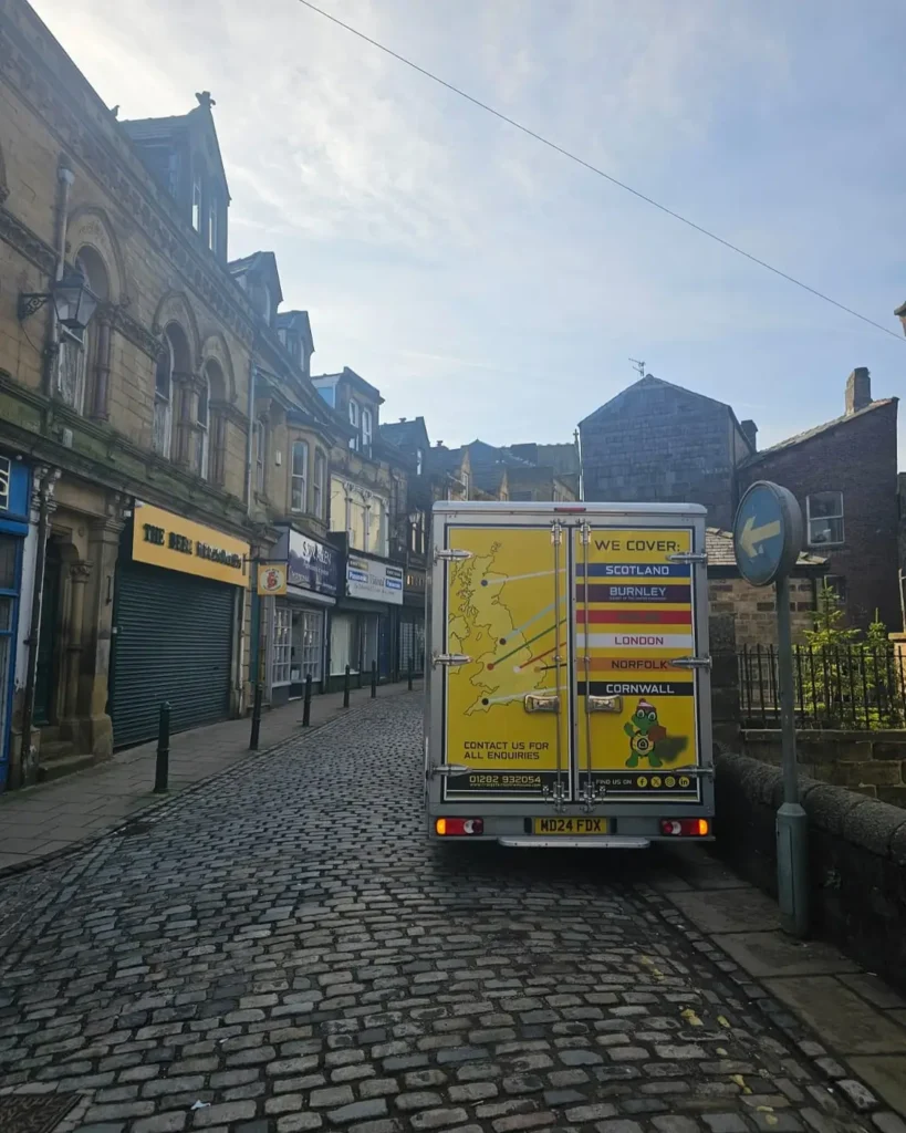 Craig Atkinson Removals van parked on a cobbled street in Burnley, showing company coverage map on the back doors.