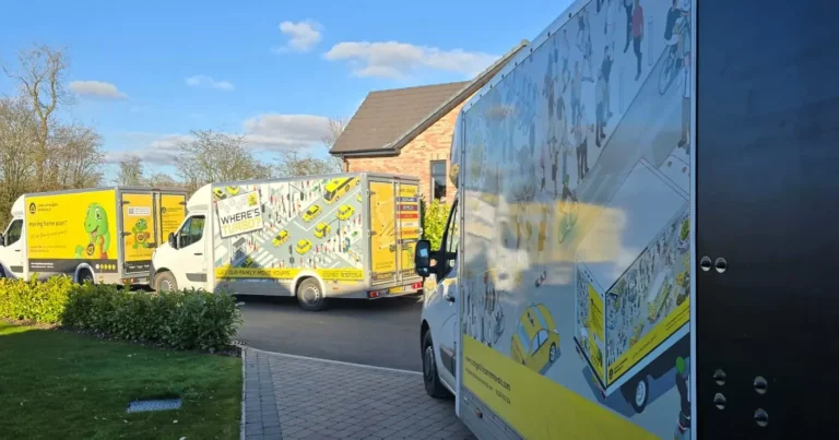 Craig Atkinson Removals vans lined up on a residential street, featuring the yellow Tommy Turbo and Where’s Turbo designs.