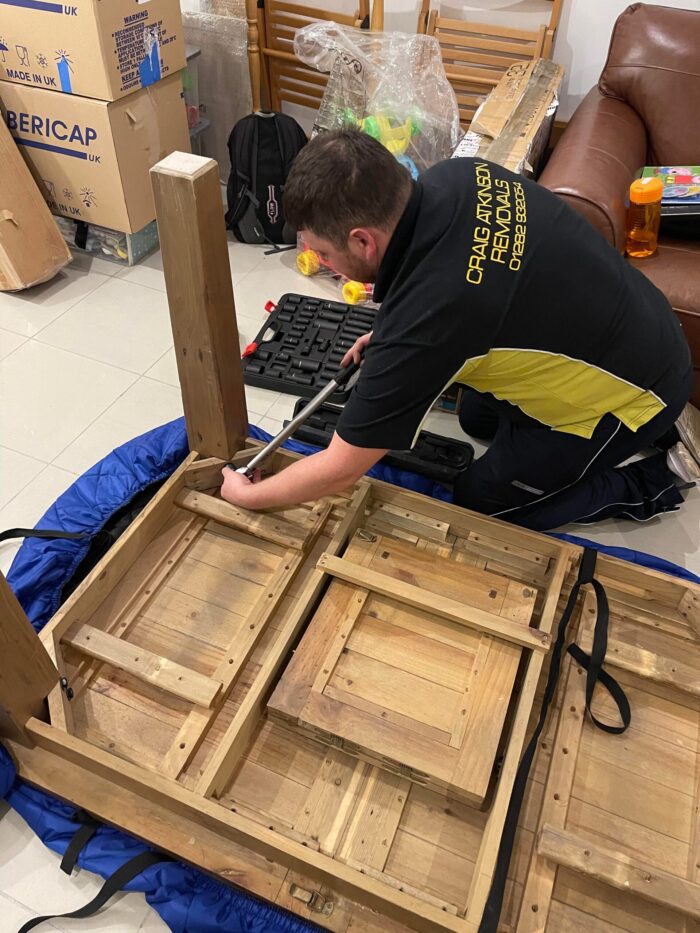 Craig Atkinson Removals team member assembling wooden furniture during a house move in Burnley