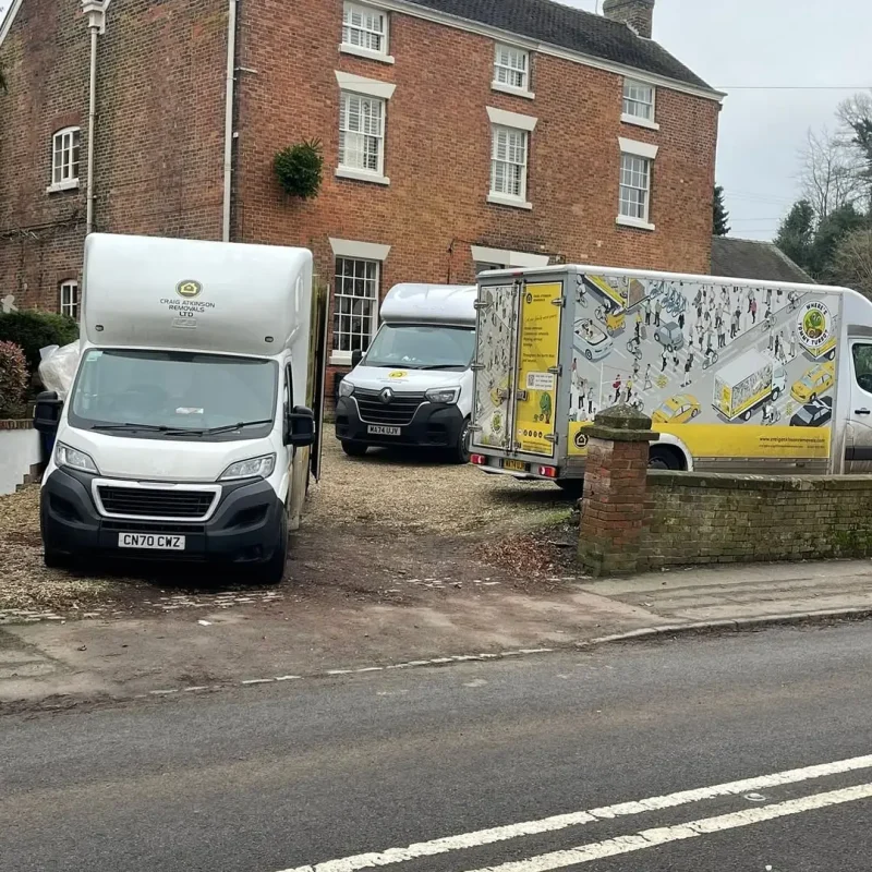 Craig Atkinson Removals vans parked outside a large brick home in Clitheroe during a professional house move.