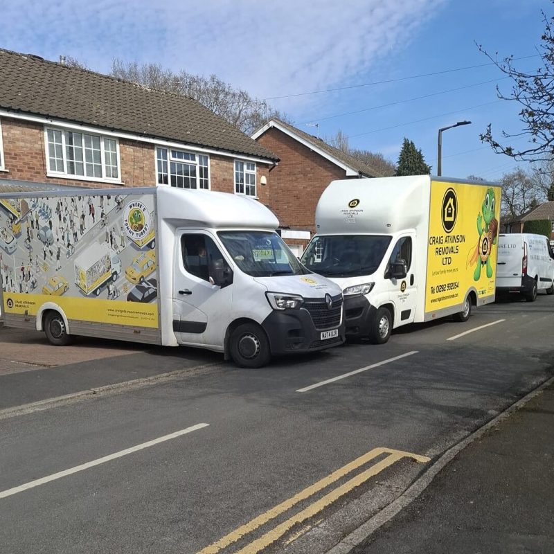 Craig Atkinson Removals vans parked outside homes during a house move, showcasing the company’s branded fleet in operation.